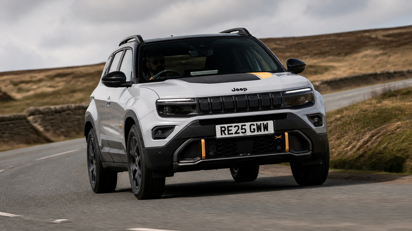 White Jeep SUV with black and yellow accents driving on a winding rural road under cloudy sky