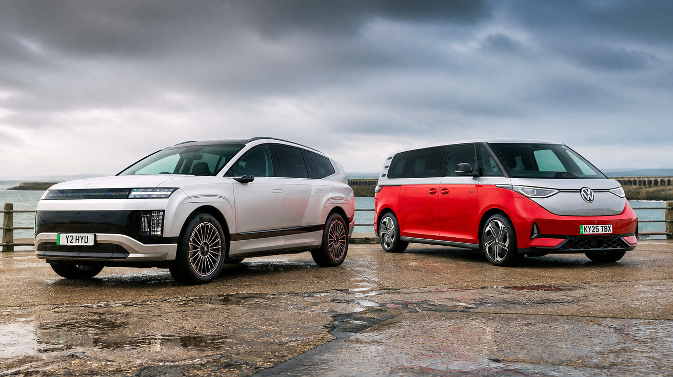 Two modern electric vehicles, a white SUV and a red minivan, parked on a wet pier under cloudy skies.